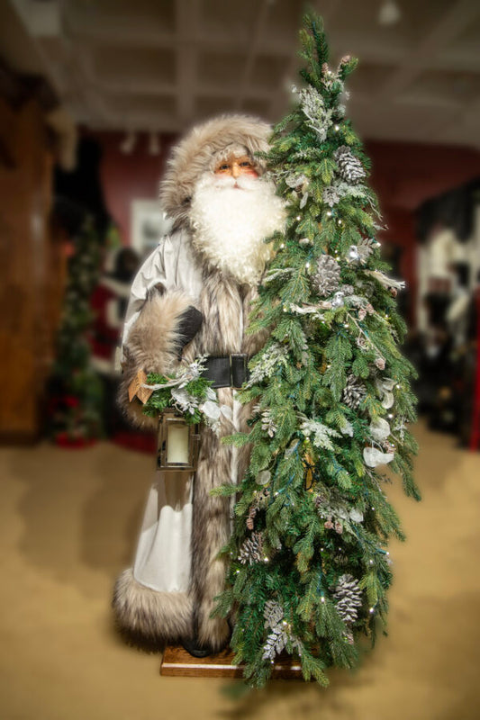 A decorative figure depicting Winter Mist Santa Claus standing next to a Christmas tree with ornaments