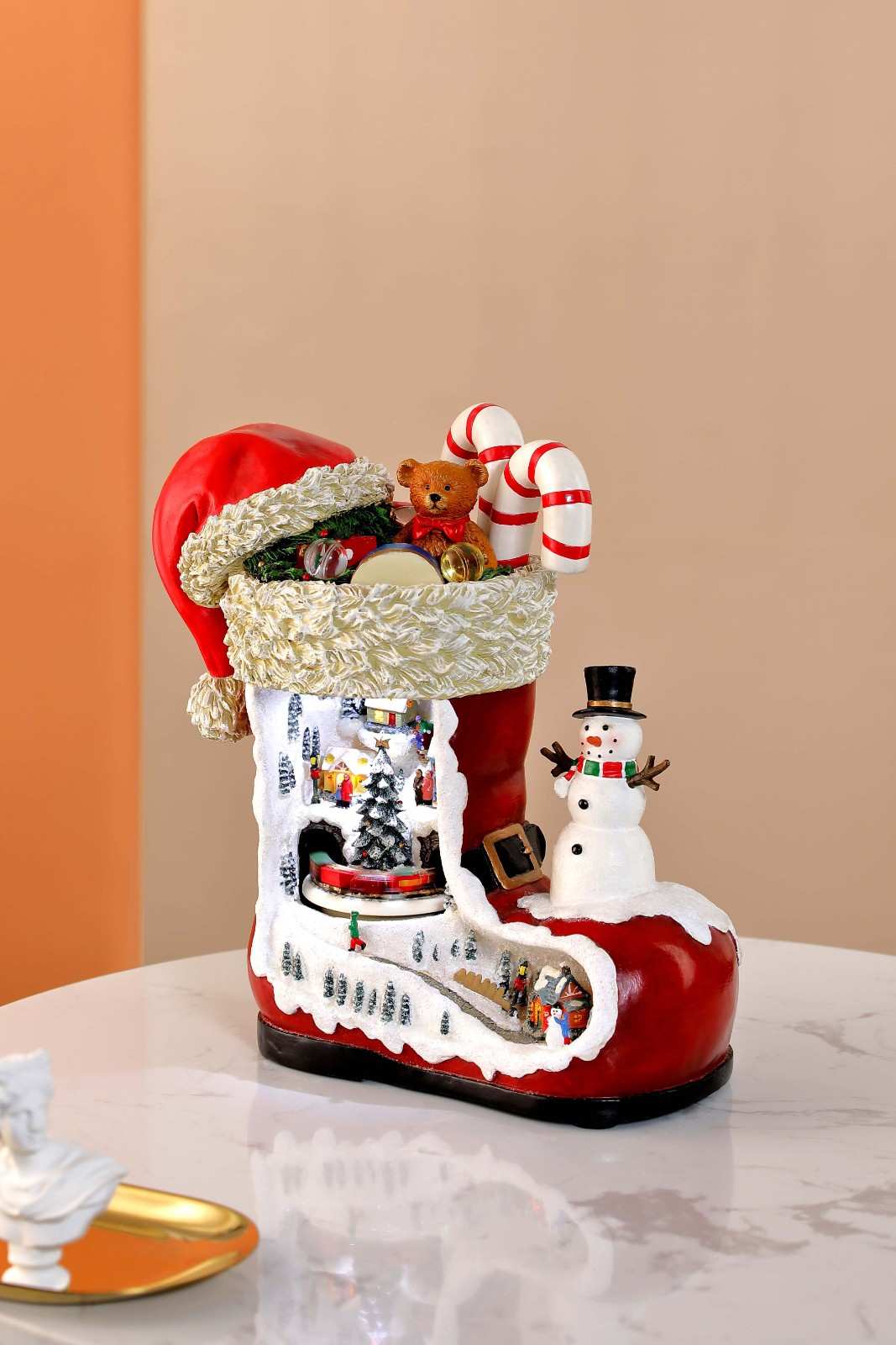 A decorative Christmas stocking with a train theme, featuring a red and white color scheme, a snowman, and an LED light display.