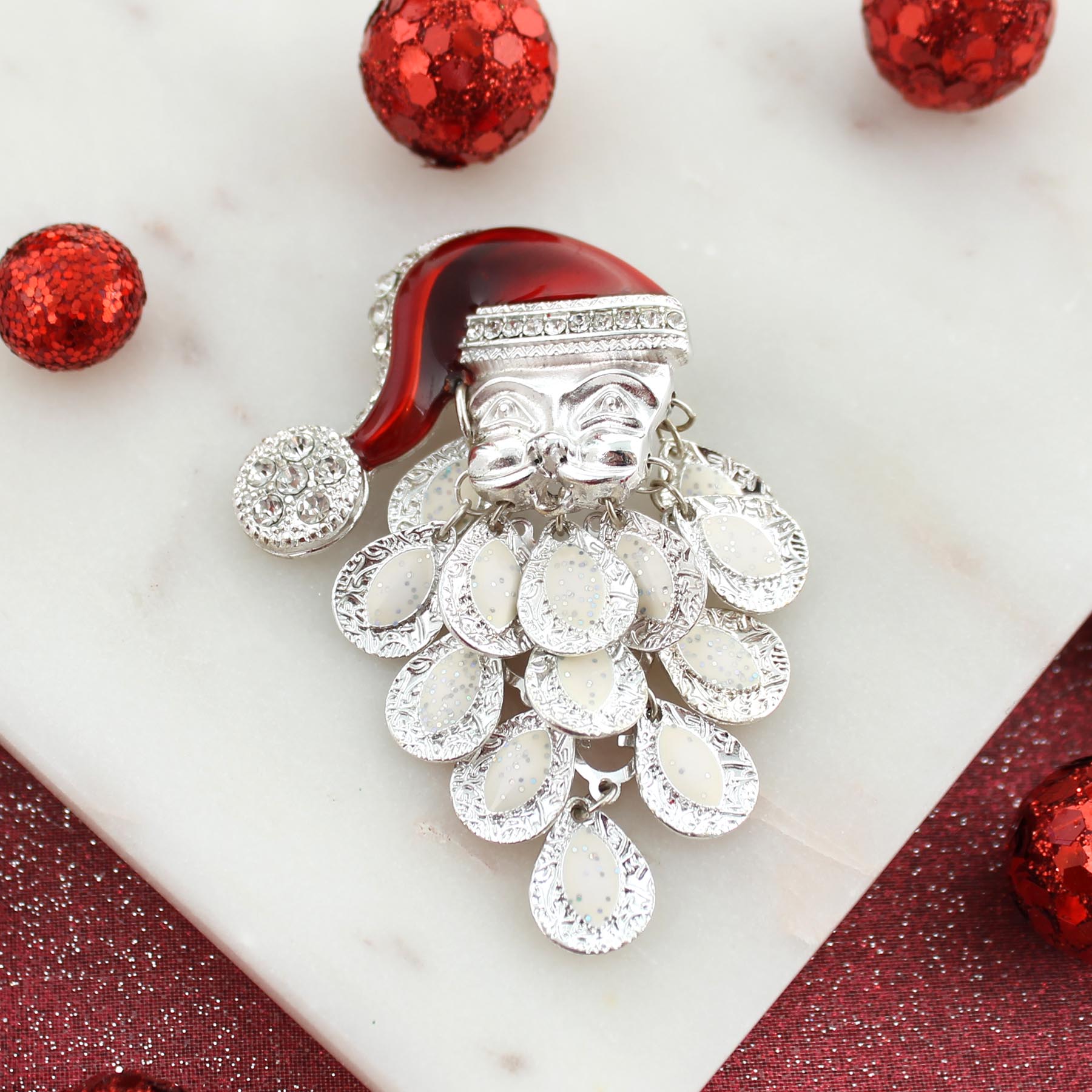 A festive Santa Claus brooch featuring red and white balls, perfect for holiday attire.